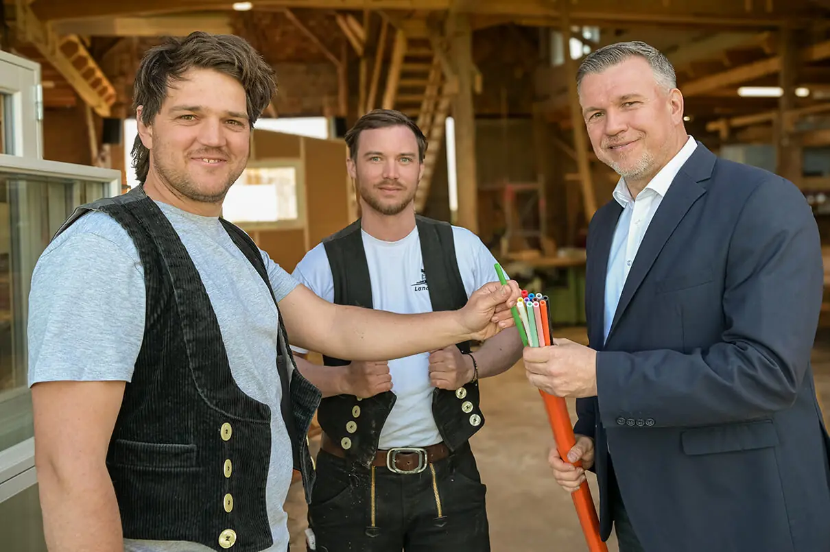 Ralf Reinhardt Kandidat Landratswahl Ostprignitz-Ruppin mit Handwerkern aus der Wirtschaft und einem Glasfaserkabel Symbol für Breitbandausbau im Landkreis OPR - Termine Ralf Reinhardt